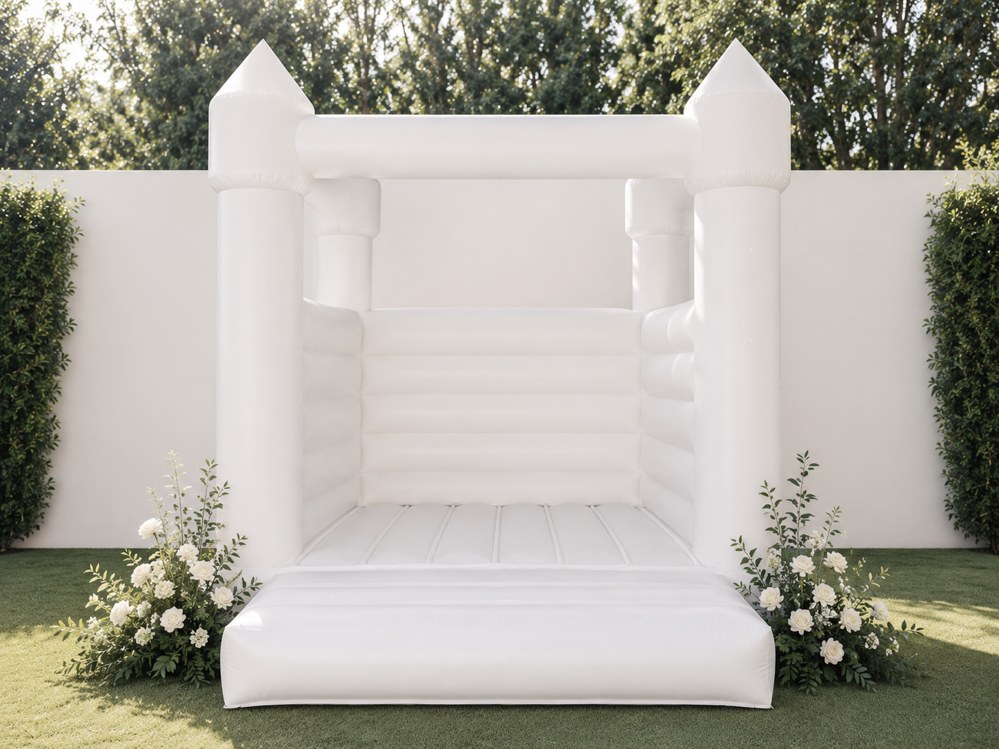 White bounce house in elegant garden setting